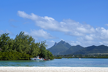 Moored coast-guard boat with the dramatic Bambous Mountain in the distance, on the exotic island of Mauritius in the Indian Ocean