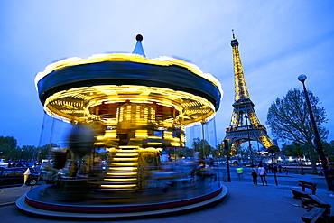 Carousel below the Eiffel Tower at twilight, Paris, France, Europe