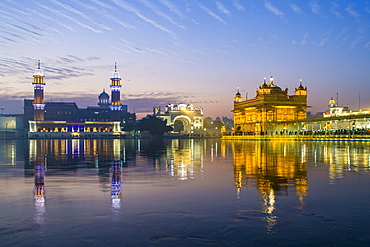 The Golden Temple (Harmandir Sahib) and Amrit Sarovar (Pool of Nectar) (Lake of Nectar), illuminated at dusk, Amritsar, Punjab, India, Asia