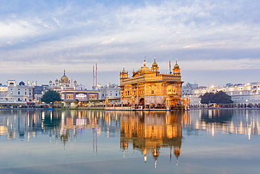 The Golden Temple (Harmandir Sahib) and Amrit Sarovar (Pool of Nectar) (Lake of Nectar), illuminated at dusk, Amritsar, Punjab, India, Asia