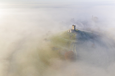 Aerial view by drone of St. Michael's Church on Burrow Mump, surrounded by a blanket of mist, Burrowbridge, Somerset, England, United Kingdom, Europe