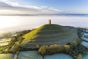 View by drone of St. Michael's Tower on Glastonbury Tor at dawn in winter, Somerset, England, United Kingdom, Europe