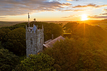 St. Dennis Parish Church emerging from trees at sunrise in autumn, St. Dennis, Cornwall, England, United Kingdom, Europe