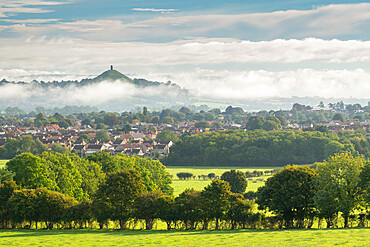 View across the town of Street towards Glastonbury Tor on a misty autumn morning, Somerset, England, United Kingdom, Europe