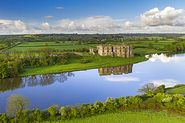 Aerial view of Carew Castle reflected in the mill pond on a still spring morning, Pembrokeshire Coast National Park, Wales, United Kingdom, Europe