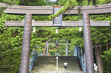 Man walking under tori gate, Hakodate, Hokkaido, Japan