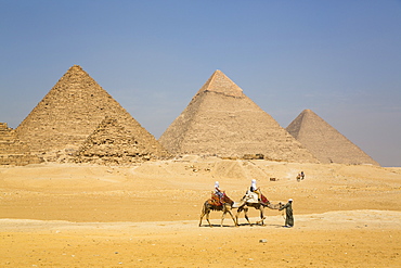 Tourists riding camels, Great Pyramids of Giza, UNESCO World Heritage Site, Giza, Egypt, North Africa, Africa