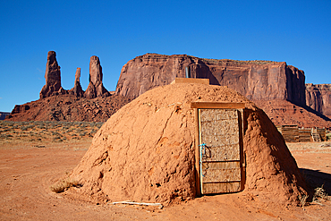 Navajo Hogan House, Three Sisters (background), Monument Valley Navajo Tribal Park, Utah, USA