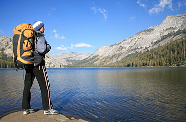 A hiker takes in the view on the shore of Tenaya Lake, in the Tuolumne Meadows, near Tioga Pass and Yosemite Valley, Sierra Nevada, California, United States of America, North America