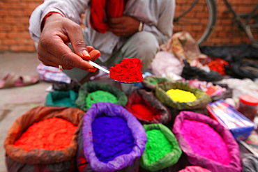 A dye trader offers his brightly coloured wares in a roadside stall in Kathmandu, Nepal, Asia