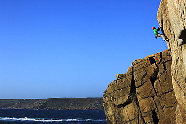 A climber tackles a difficult route on the cliffs near Sennen Cove, a popular rock climbing area at Lands End, Cornwall, England, United Kingdom, Europe