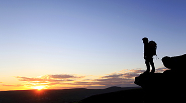 A hiker at sunset on Bamford Edge, near Edale, Peak District, Derbyshire, England, United Kingdom, Europe