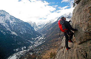 A climber moves along the steel cables on the Fressinieres via ferrata, above the Fressinieres valley, near Briancon, Ecrins Massif, western Alps, Hautes-Alpes, south east France, Europe