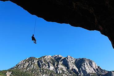 A climber lowers off a very overhanging cave climb on the cliffs above Bielsa, Spanish Pyrenees, Aragon, Spain