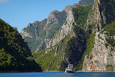 Lake Koman, a reservoir on the Drin River in northern Albania, surrounded by dense forested hills, vertical slopes, deep gorges, and a narrow valley, Albania, Europe