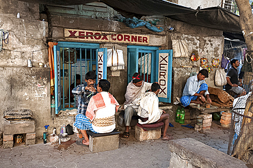 Barbers cutting hair and shaving men, and tobacco wallah, in street stalls outside Xerox shop in Dalhousie Square area of Kolkata (Calcutta), West Bengal, India, Asia