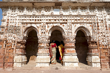 Two women in saris visiting the Lalji terracotta Hindu temple, built in 1739 and dedicated to Radha Krishna, Kalna,West Bengal, India, Asia