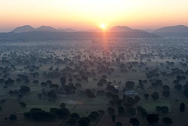 Sun rising over the hills and countryside surrounding Samode, from hot air balloon, Rajasthan, India, Asia