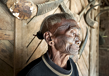 Bengshe Bengsha, elderly Naga tribal headhunter with traditional tattooed face and hair knot, Longwa village, Nagaland, India, Asia