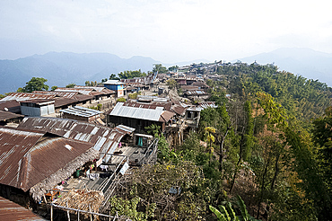 Naga village houses clinging to the hillside leading up to Baptist church at the top, Chanlangshu village, Nagaland, India, Asia