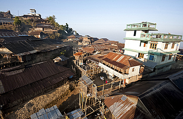 Naga village houses with bamboo stilted verandahs, clinging to the hillside, in morning light, Chanlangshu village, Nagaland, India, Asia