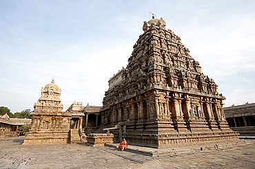 Woman in orange sari sitting beside the vimala section of Swaminathaswamy temple dedicated to Murugan, Swamimalai, Tamil Nadu, India, Asia