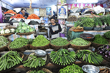 Two cheerful young men running a fresh vegetable stall in the main city vegetable market, Bhuj, Gujarat, India, Asia