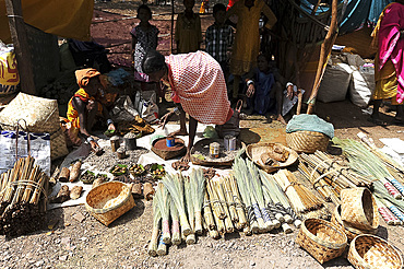 Dhuruba women at tribal market stall selling tree resins used for mosquito repellent, millet, and fruits to dry, Jeypore, Odisha, India, Asia