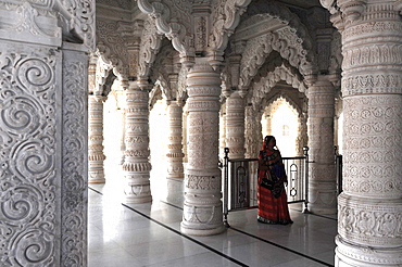 Hindu woman in red sari inside the ornate white marble Swaminarayan Temple, built following the 2001 earthquake, Bhuj, Gujarat, India, Asia