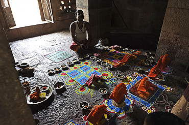 Priest arranging puja ceremony inside 7-8th century Parashurameshvara Temple, Bhubaneswar, Odisha, India, Asia