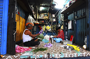 Two men in Malik Ghat flower market threading floral garlands, Kolkata, West Bengal, India, Asia