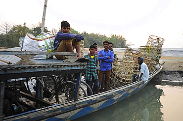 Village men with baskets and bicycles, on the local village ferry waiting to cross the Brahmaputra river, Assam, India, Asia