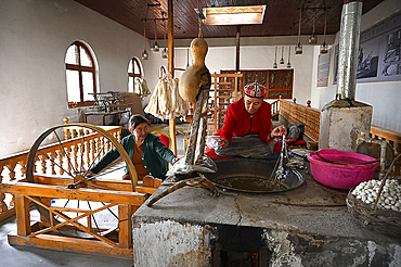 Uyghur women spinning silk thread from cocoons in traditional silk workshop, Jiya, Xinjiang, China, Asia