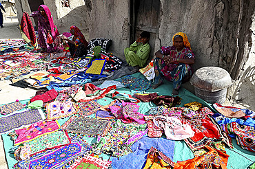 Women displaying their hand embroidered cloths, garments and bags in the desert village of Jarawadi, Kutch, Gujarat, India, Asia