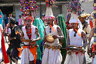 Adivasi tribal men, faces and bodies decorated, wearing ornate headgear, dancing to celebrate Holi festival, Kavant, Gujarat, India, Asia