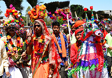 Adivasi tribal men, faces and bodies decorated, wearing ornate headgear, dancing to celebrate Holi festival, Kavant, Gujarat, India, Asia