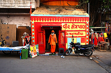 Hindu pundit dressed in holy orange at tiny Hindu temple near Gomati ghat, Dwarka, Gujarat, India, Asia