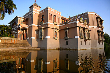 Approaching Sri Joravar Vilas reflected at sunset in the waters of the lake beside which it stands, Santrampur, Gujarat, India, Asia