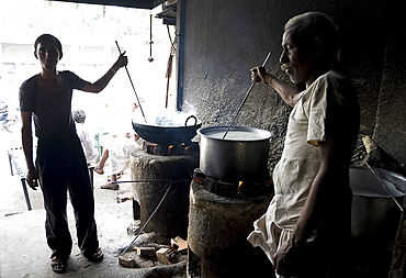 Young man and blind man stirring milk for chai, roadside chai stall, Dangiyawas, Rajasthan, India, Asia