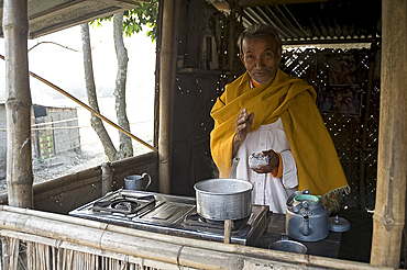 Village chai wallah (teamaker) makes the first brew of the day, Kurua village, Assam, India, Asia