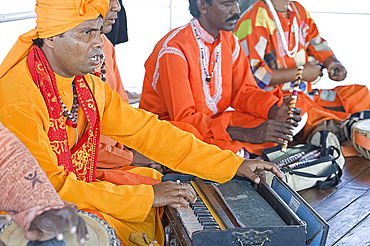 Hindu musicians singing ragas and playing ten scale Indian harmonium keyboard, tabla, pipe and hand cymbals, West Bengal, India, Asia