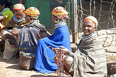 Bonda tribeswomen in traditional dress with beaded caps and metal necklaces selling beads at weekly market, Rayagader, Orissa, India, Asia