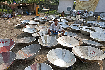 Man selling metal animal feed dishes at Sonepur Cattle Fair, Bihar, India, Asia