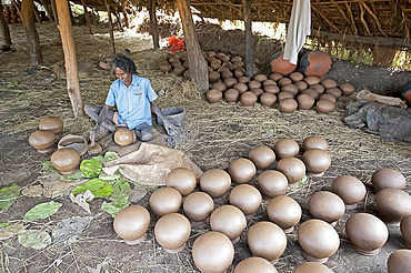 Potter making clay water pots in a thatched shelter in a rural village, near Rayagada, Orissa, India, Asia