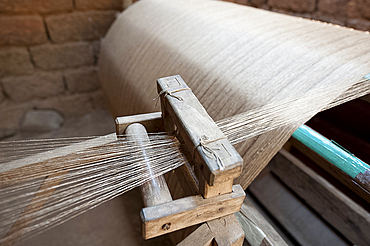 Silk thread being spun on large handmade wooden wheel, rural Orissa, India, Asia