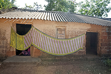 Cotton sari being hung out to dry across village house wall, rural Orissa, India, Asia