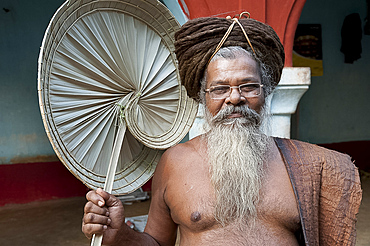 Joranda monk wearing tree bark cloth, holding palm leaf fan, with uncut hair piled up on top of his head, Joranda, Orissa, India, Asia