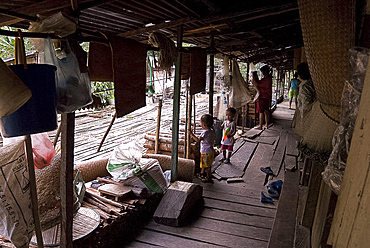 Iban tribal villagers sheltering from the rain on their longhouse verandah, Lemanak River, Sarawak, Malaysian Borneo, Malaysia, Southeast Asia, Asia