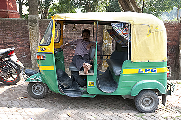 Rickshaw wallah waiting for custom in his rickshaw (tuk tuk), Barrackpore, West Bengal, India, Asia