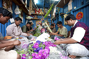 Mala makers (garland makers) at work in Kolkata's morning flower market, Howrah, Kolkata, West Bengal, India, Asia